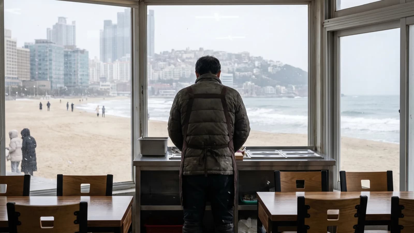 한산한 겨울 해변이 보이는 소형 수제버거 매장을 지키는 점주