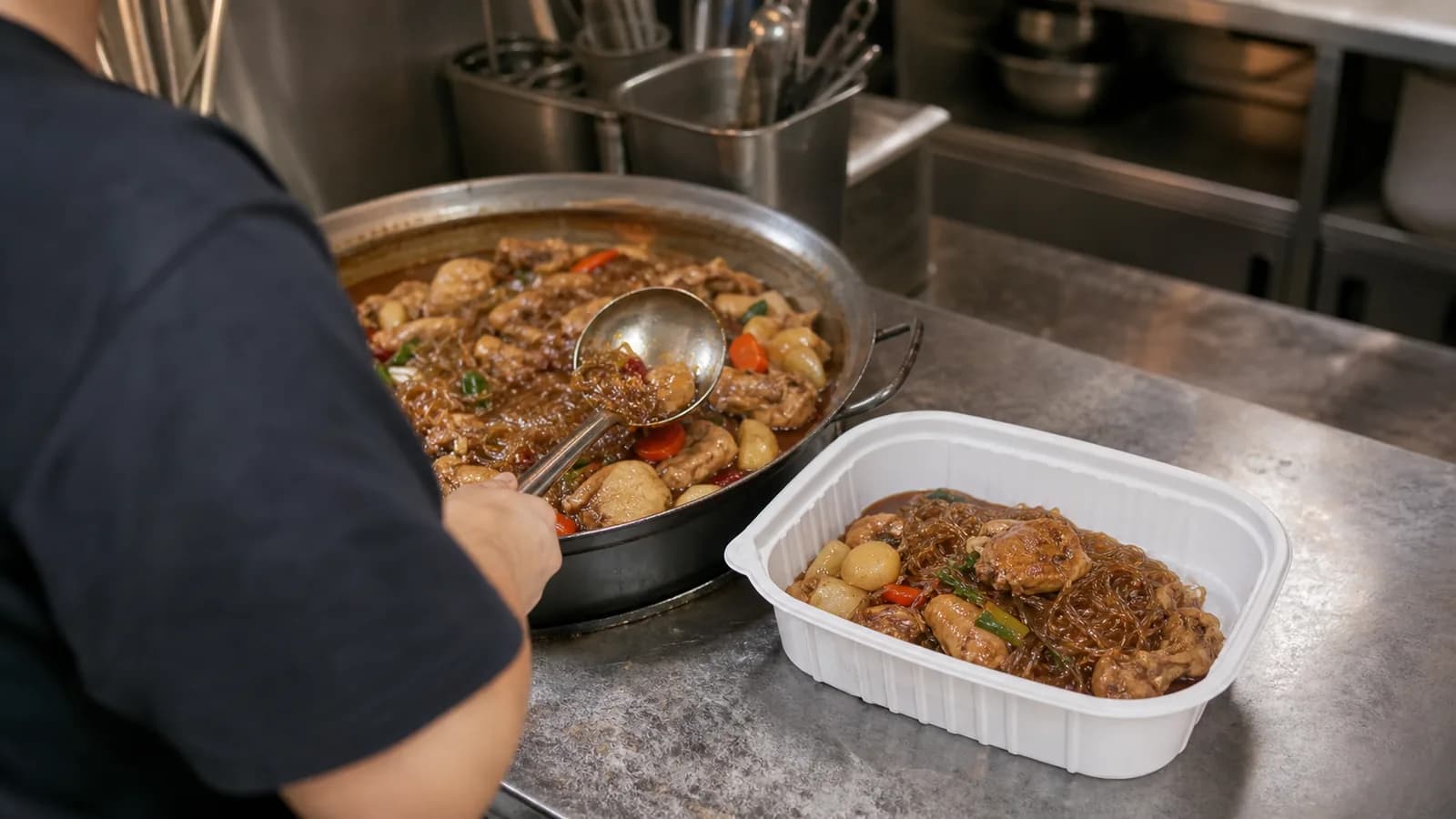 조리한 찜닭을 배달 용기에 옮겨 담는 소형 식당 주방